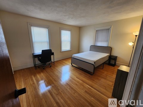 A bedroom with a bed, chair, and desk.