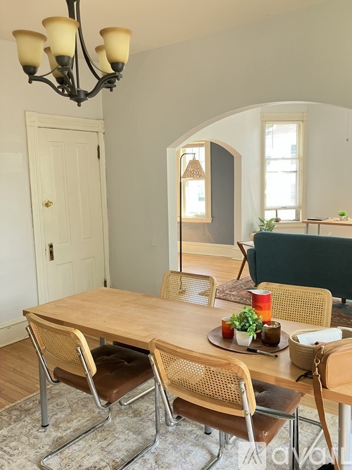 A dining room with a wooden table and chairs.