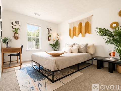 A bedroom with a bed, desk, and chair.