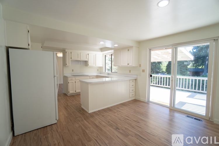 A kitchen with white appliances and cabinets is available for rent.