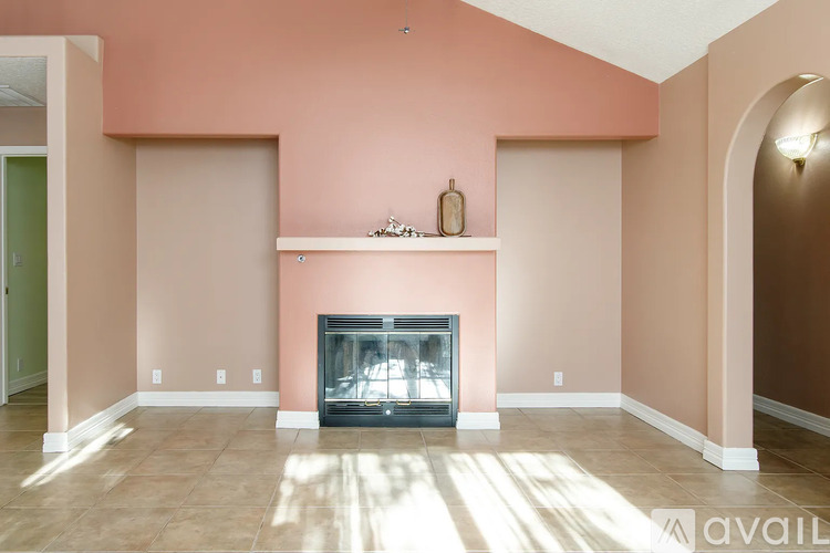 A living room with a fireplace and a wall-mounted shelf.