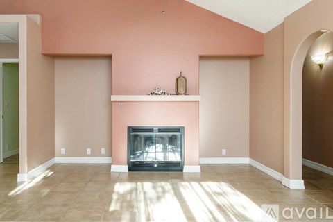 A living room with a fireplace and a wall-mounted shelf.