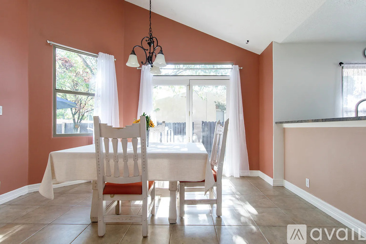 A dining room with a table and chairs.