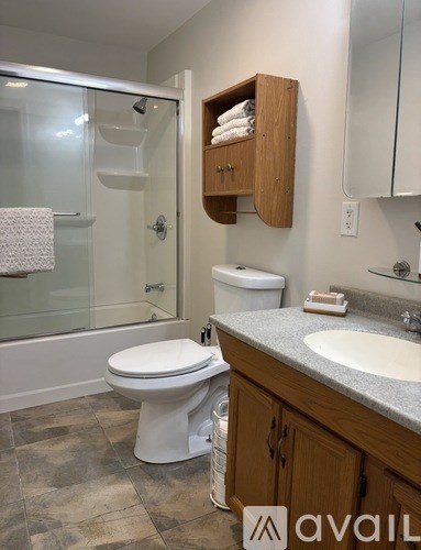 A bathroom with a toilet, sink, and shower.