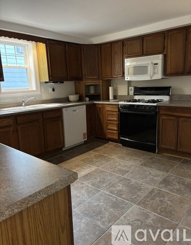 A kitchen with wooden cabinets and a black stove top oven.