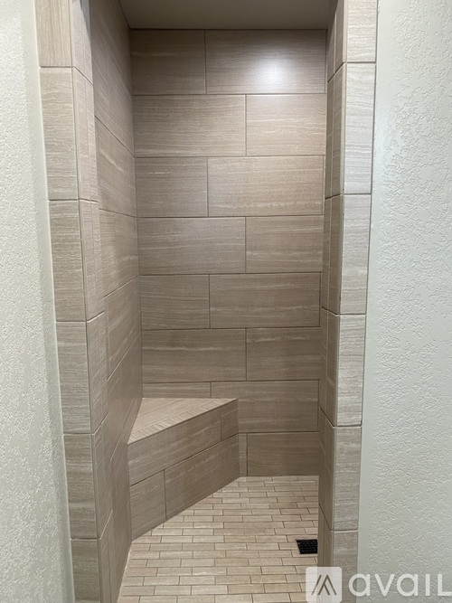 A tiled shower stall with a bench seat.