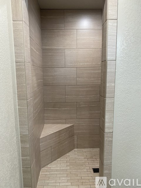 A tiled shower stall with a bench seat.
