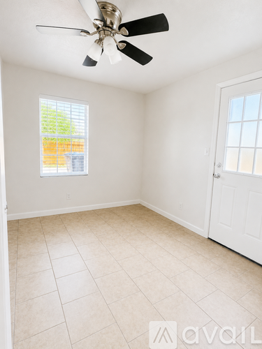 A room with a ceiling fan and a window.