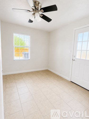 A room with a ceiling fan and a window.