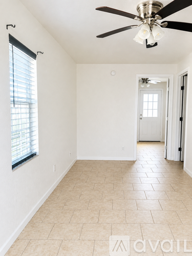 A room with a ceiling fan and tiled flooring.