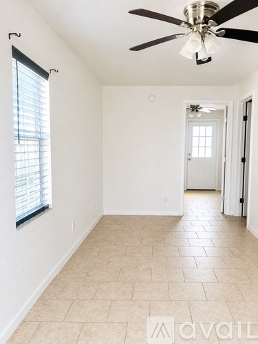 A room with a ceiling fan and tiled flooring.
