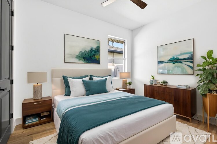 A bedroom with a bed, nightstands, and two framed pictures on the wall.