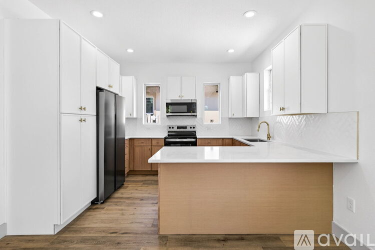 A modern kitchen with white cabinets and a wooden island.