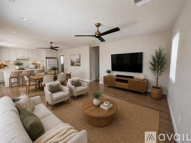 A living room with a white couch, a coffee table, and a television.