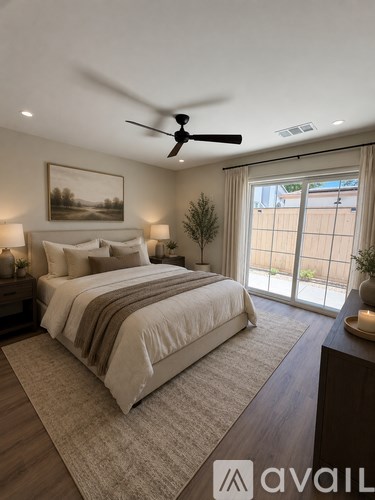 A bedroom with a large bed and a ceiling fan.