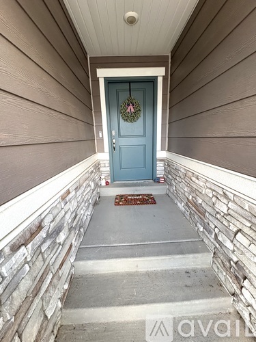 A blue door with a wreath on it is the centerpiece of this image.