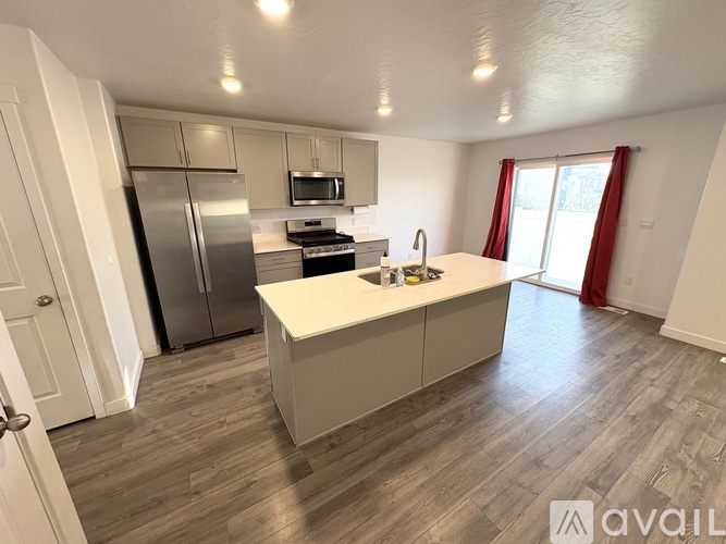 A kitchen with a refrigerator, microwave, oven, and sink.