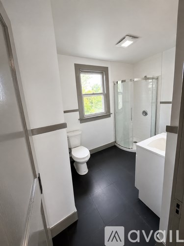 A bathroom with a toilet, sink, and shower.