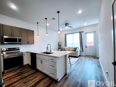 A modern kitchen with wooden floors and a large island.