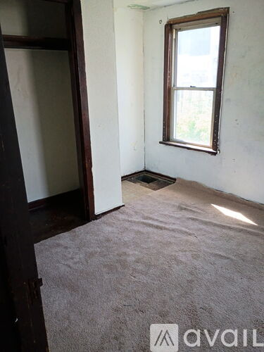 A room with a carpeted floor and a window.