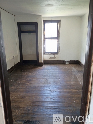 A room with wooden floors and a window.