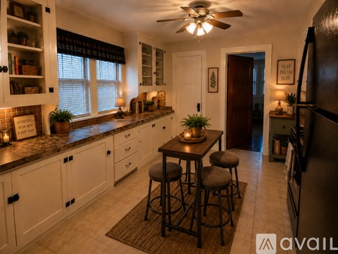A kitchen with white cabinets and a dark counter top.