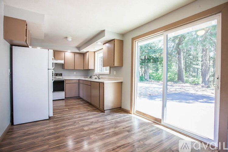 A kitchen with wooden floors and white appliances.