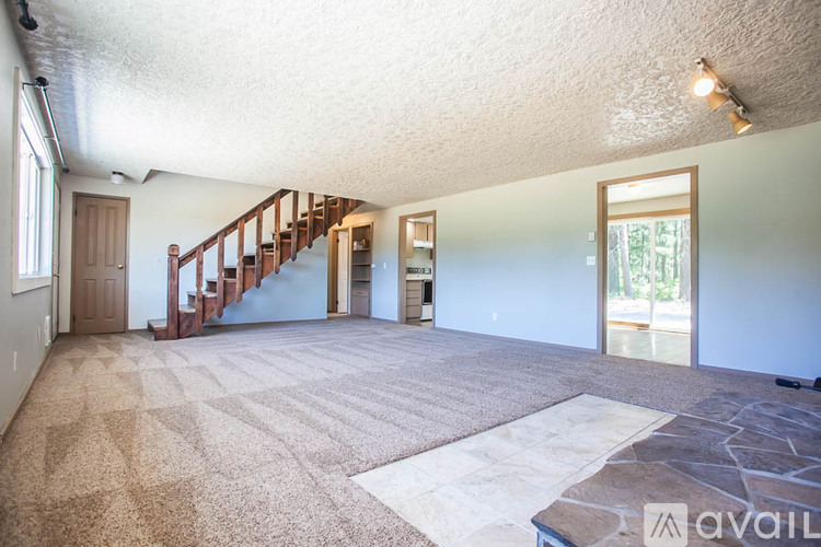 A spacious room with a staircase and a carpeted floor.