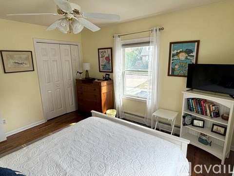 A bedroom with a large bed and a ceiling fan.