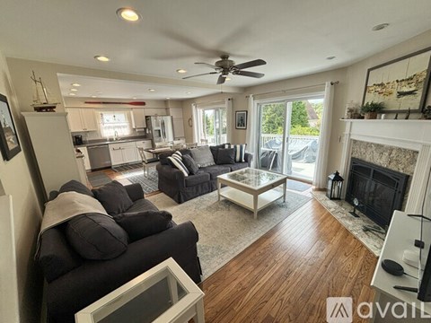 A living room with a black couch and a fireplace.
