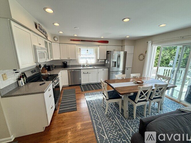 A kitchen with a dining table and chairs in the middle of the room.