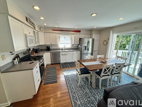 A kitchen with a dining table and chairs in the middle of the room.