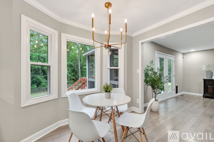 A dining room with a white table and chairs and a chandelier.