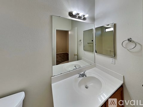 A bathroom with a white sink and a mirror above it.
