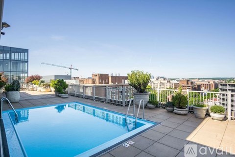 A swimming pool on a rooftop patio with a view of the city.