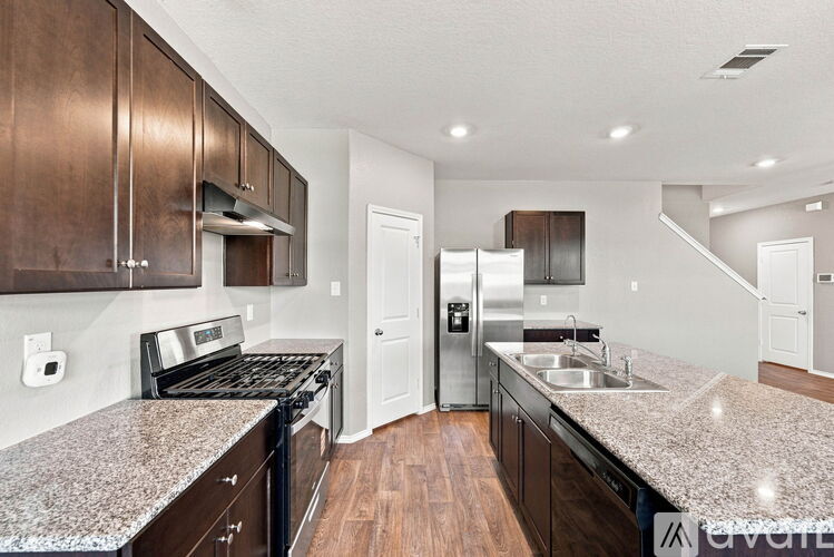 A kitchen with dark wood cabinets and granite countertops.