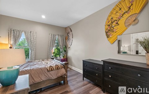 A bedroom with a bed, dresser, and mirror.