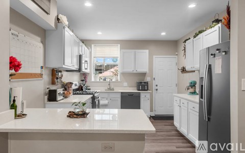 A kitchen with white cabinets and a large island.