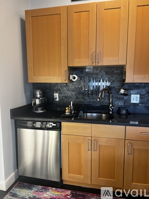 A kitchen with wooden cabinets and a black counter top.