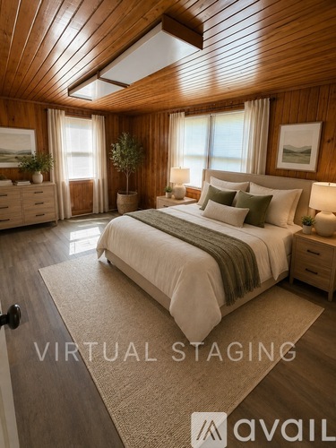 A bedroom with a bed, nightstands, and a window.