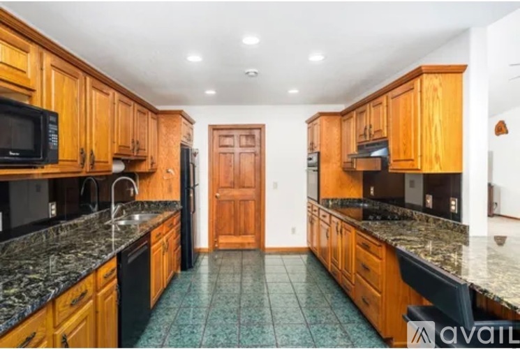 A kitchen with wooden cabinets and granite countertops.
