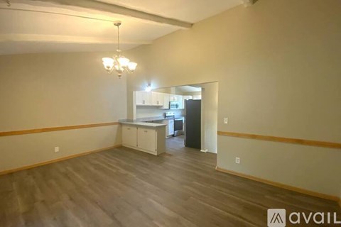 A room with a kitchenette and a chandelier.