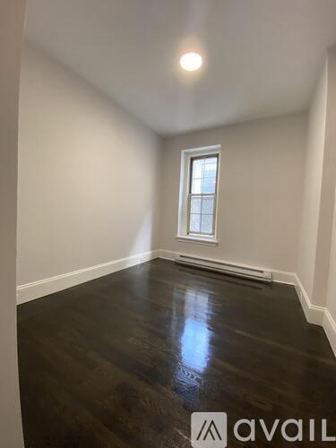 A room with a window and wooden floors.
