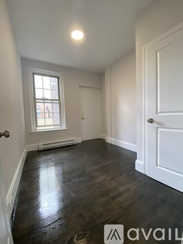 A room with a window and a door is available for rent.