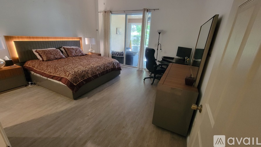 A bedroom with a large bed and a desk with a chair.