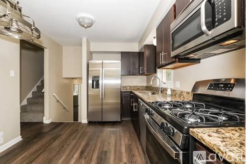 A kitchen with a stove top oven and a microwave above it.