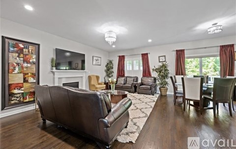 A living room with a brown leather couch and a fireplace.