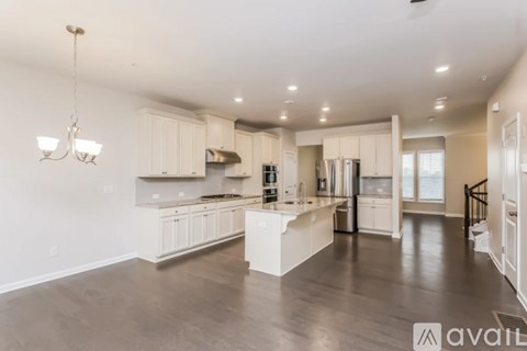 A spacious kitchen with white cabinets and a center island.