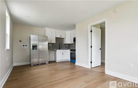 A kitchen with white cabinets and a wooden floor.