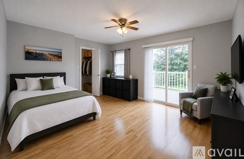 A bedroom with a bed, a chair, and a television.